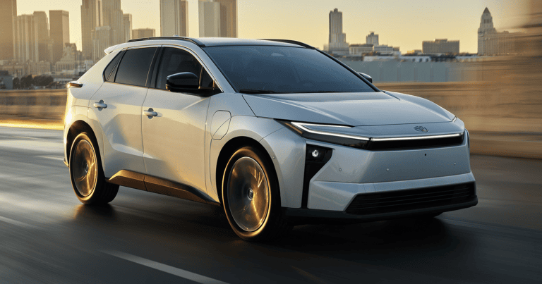 white 2026 Toyota bZ driving on road with skyline In the back